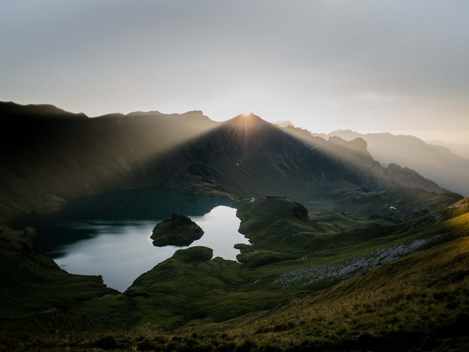 Alpin Lodges Oberjoch – Exklusive Ferienwohnungen mit Wellness Sonnenaufgang über Bergsee und grünen Hügeln in den Alpen