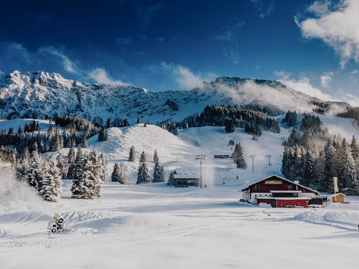 Skifahren lernen im Herzen des Allgäus Verschneite Berglandschaft mit Skihütte, Bäumen und blauem Himmel