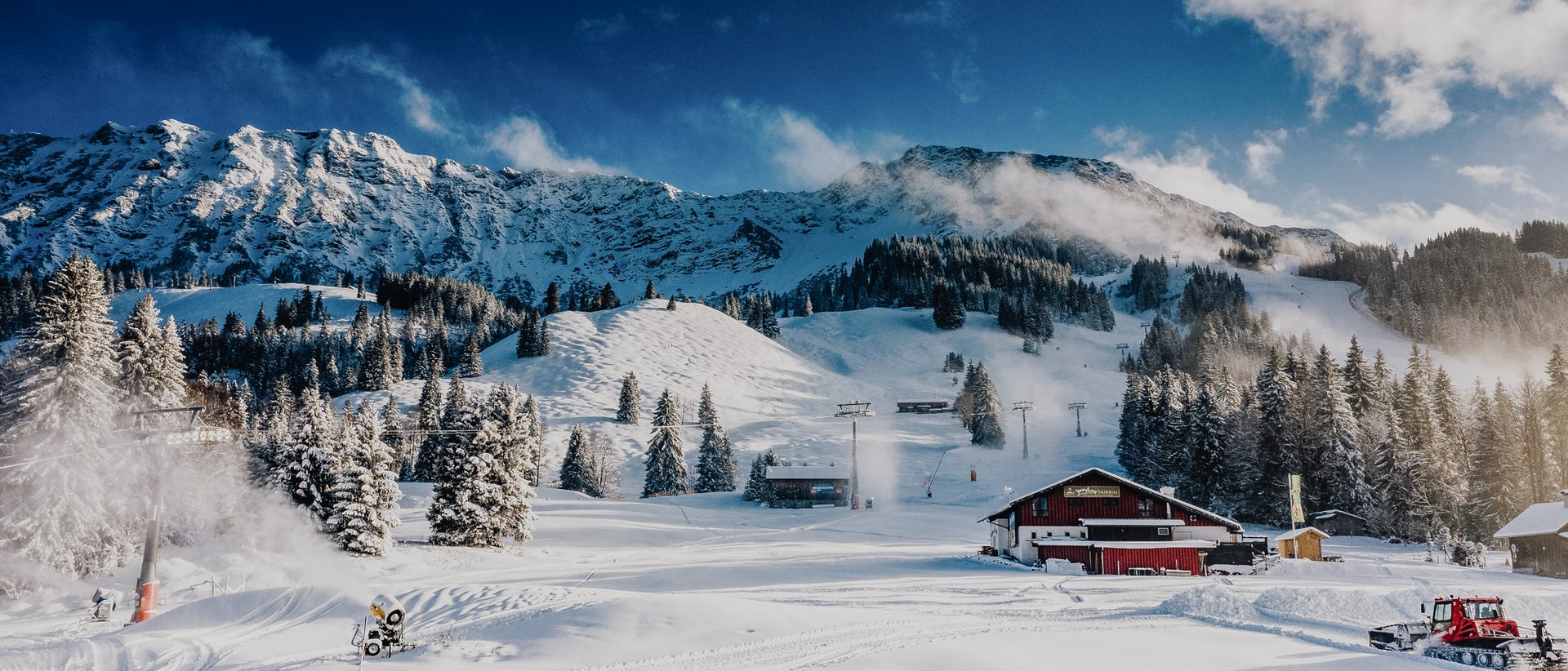 Skifahren lernen im Herzen des Allgäus Verschneite Berglandschaft mit Skihütte, Bäumen und blauem Himmel